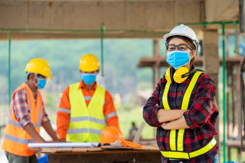 Bauarbeiter mit Schutzkleidung und Atemmaske auf der Baustelle.