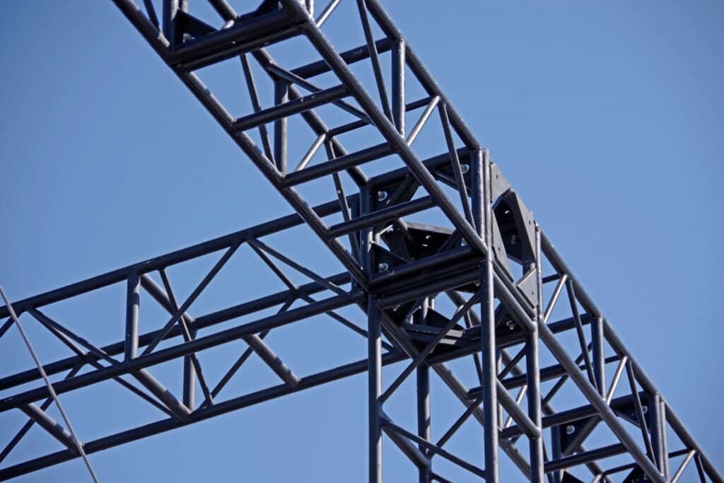 Nahaufnahme einer stabilen Metalltragekonstruktion fuer die Montage von Eventzelten bei blauem Himmel