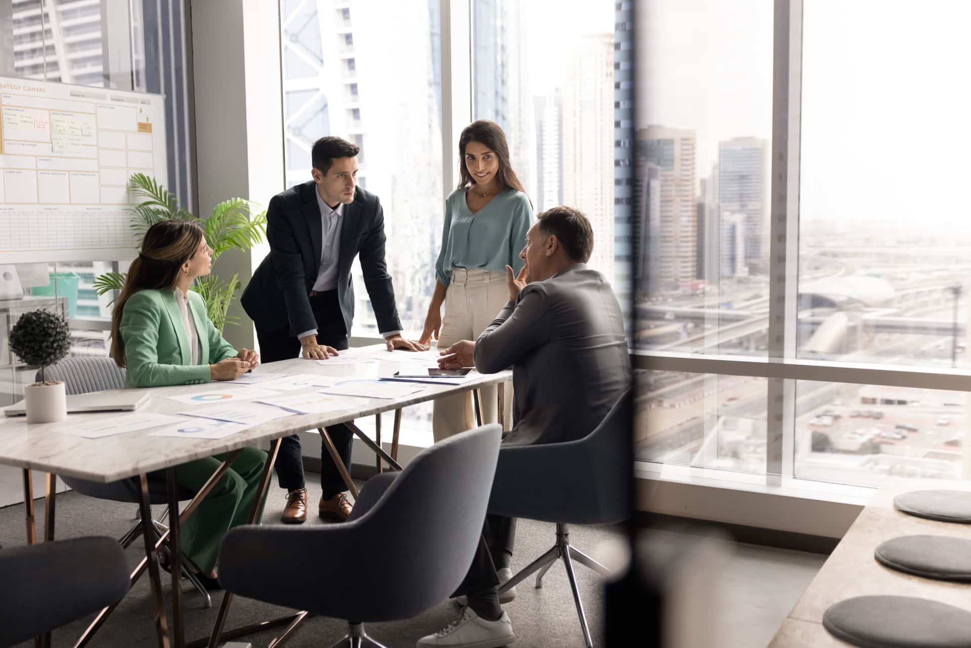 Team im Buero bei Besprechung zur Organisation von Eventzelten mit Stadtblick im Hintergrund