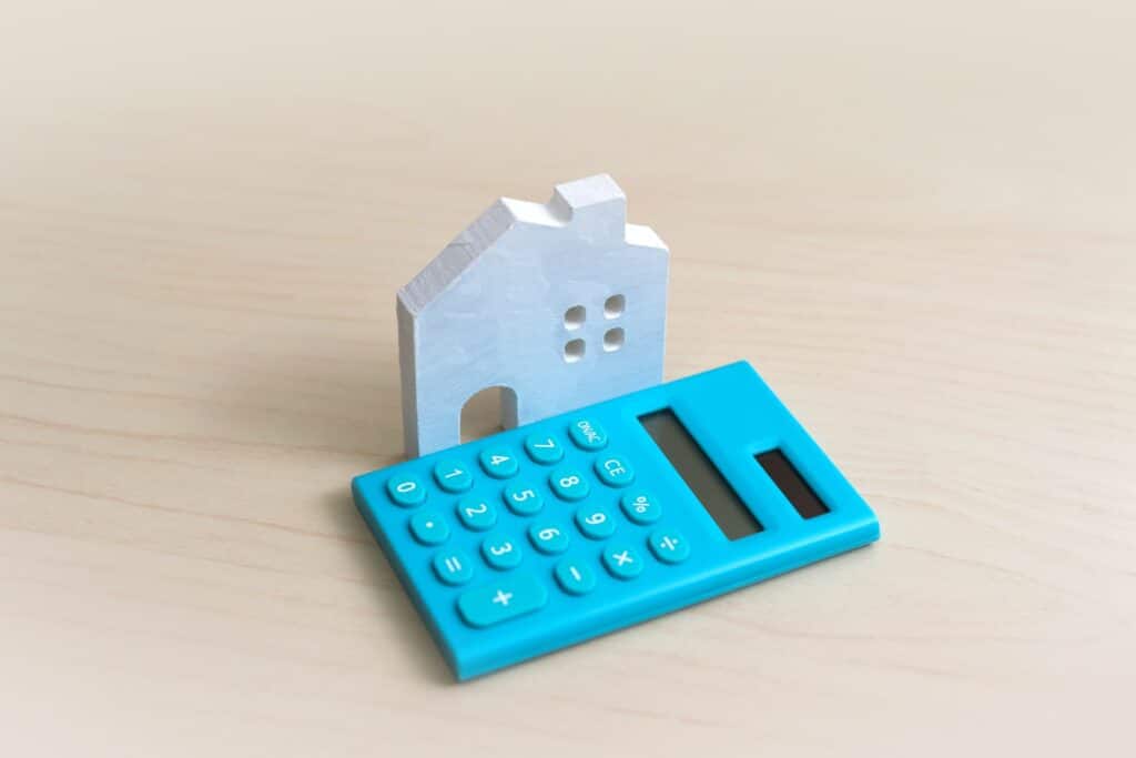 Kleines Hausmodell steht neben Taschenrechner | Schallschutzwände