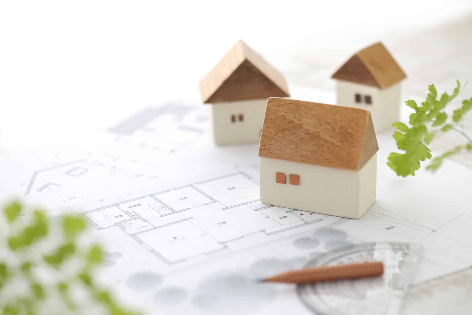 Modellhäuser liegen auf Bauplänen und Entwürfen | Schallschutzwände